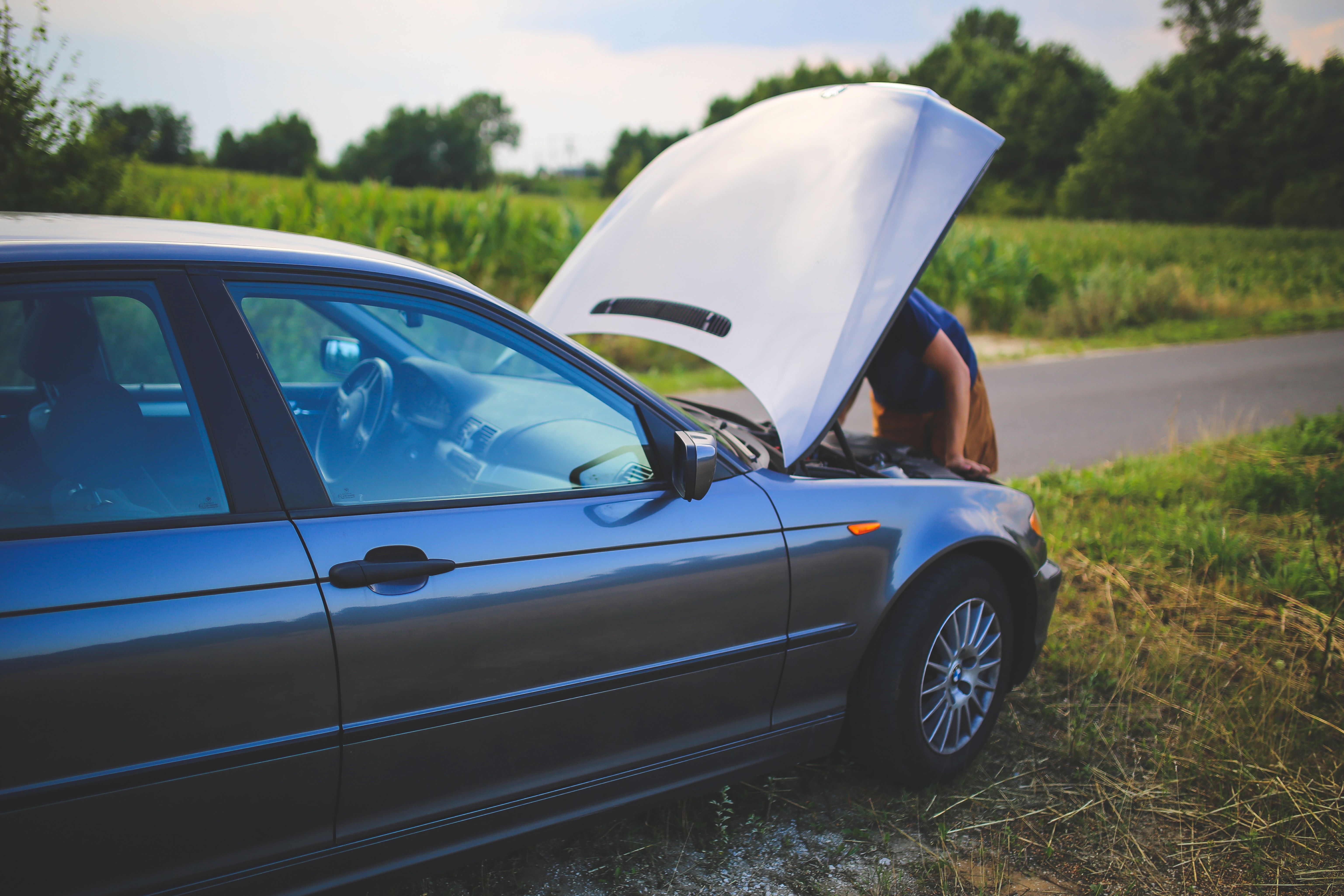 Person inspecting vehicle's engine